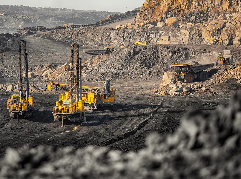 Drilling machine borer installing cast explosives blasting. Open coal mine.