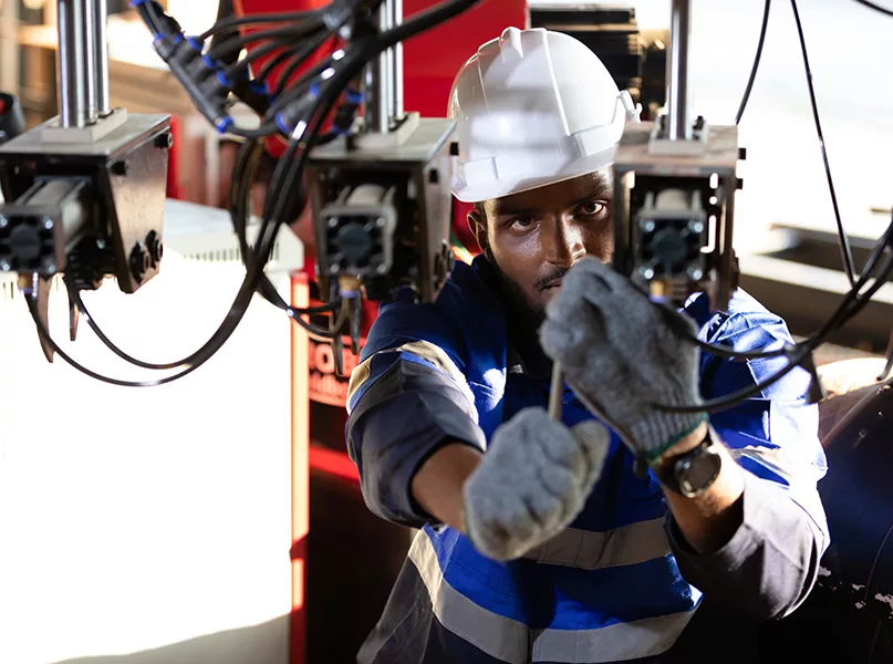 African engineer or worker checking and fixing machine in robot