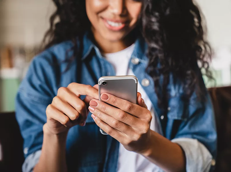 Young woman using smart phone at home.