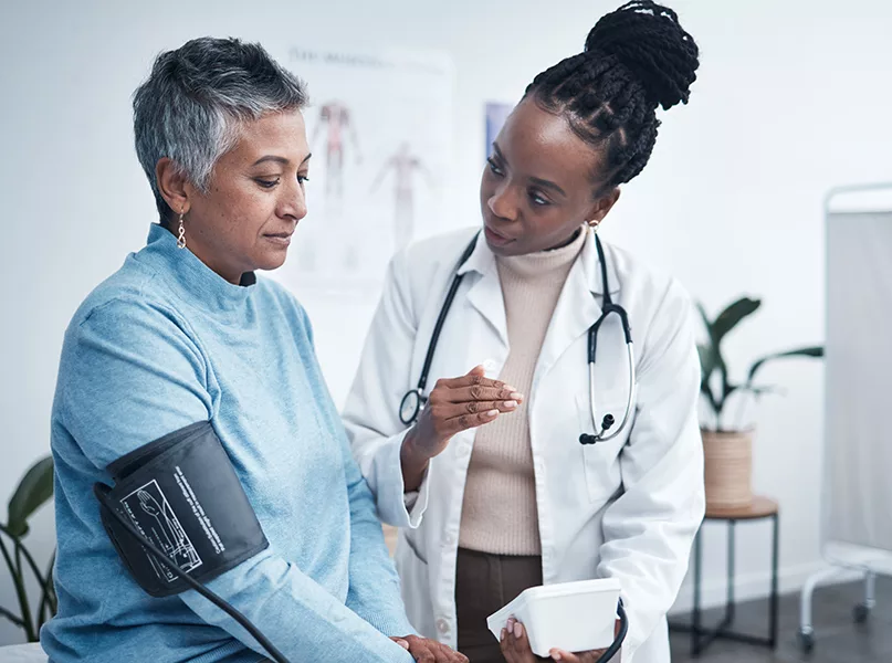 Doctor and senior patient with blood pressure reading.