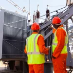 electricians standing next to a transformer