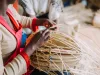 Woman weaving basket out of bamboo