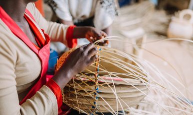 Woman weaving basket out of bamboo