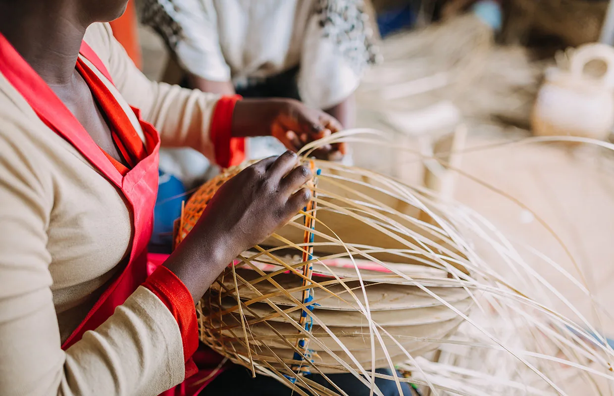 Woman weaving basket out of bamboo