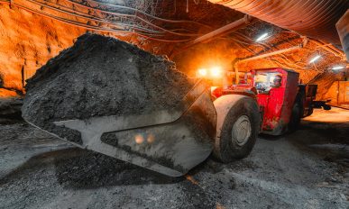 An underground loading machine carries a full bucket of ore. © istock/ukwazi