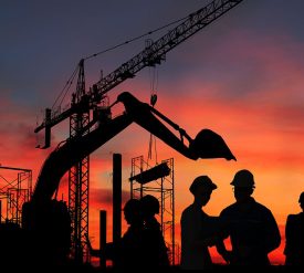 Silhouette engineer standing orders for construction crews and Excavator and machinery in an outdoor mine