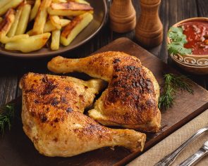 Roasted chicken legs with fried potatoes and tomato dip.