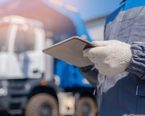 Dump truck driver man in uniform with tablet computer controls loading of cargo or coal